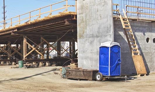 a lineup of sanitized portable toilets on a busy work site